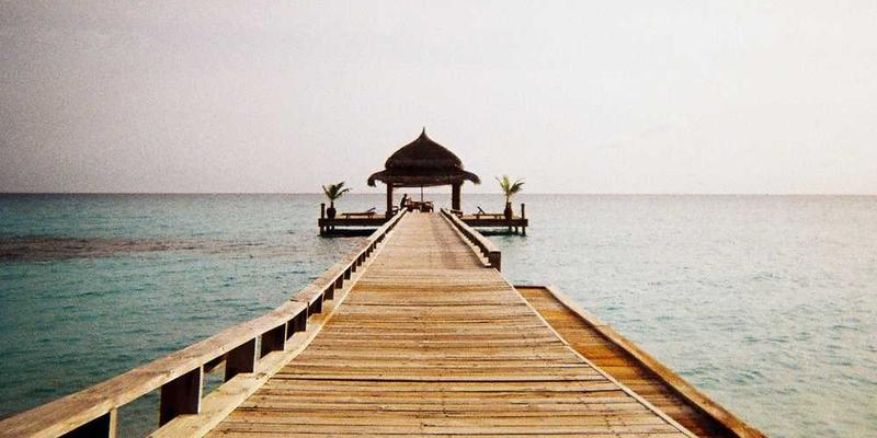 说明：一位行走在陌生街道上，手持手机查看导航地图的年轻人，表情略显紧张。