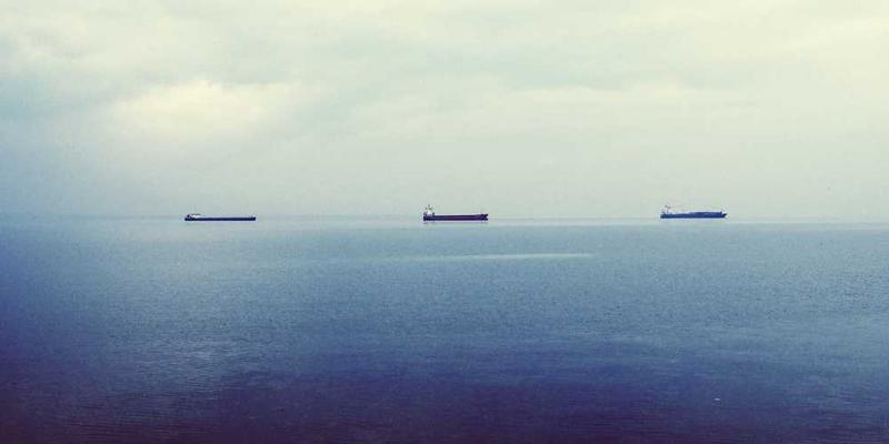 一位男士在风雨中坚守岗位，背景是高耸的建筑物，体现面对压力坚守价值观的精神